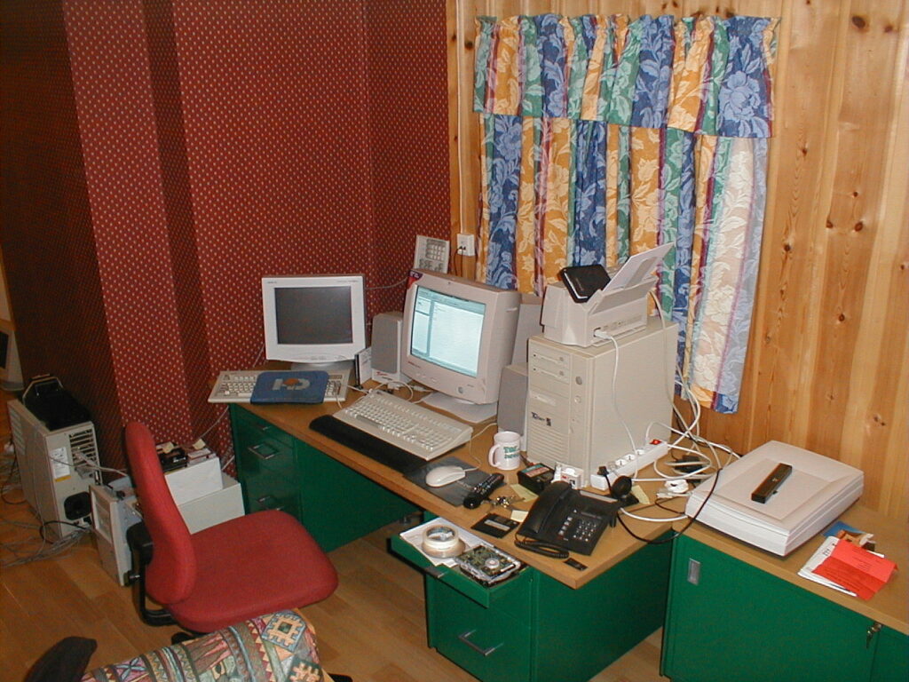 A desk filled with computers, monitors and various other computer related items. Early 2000.